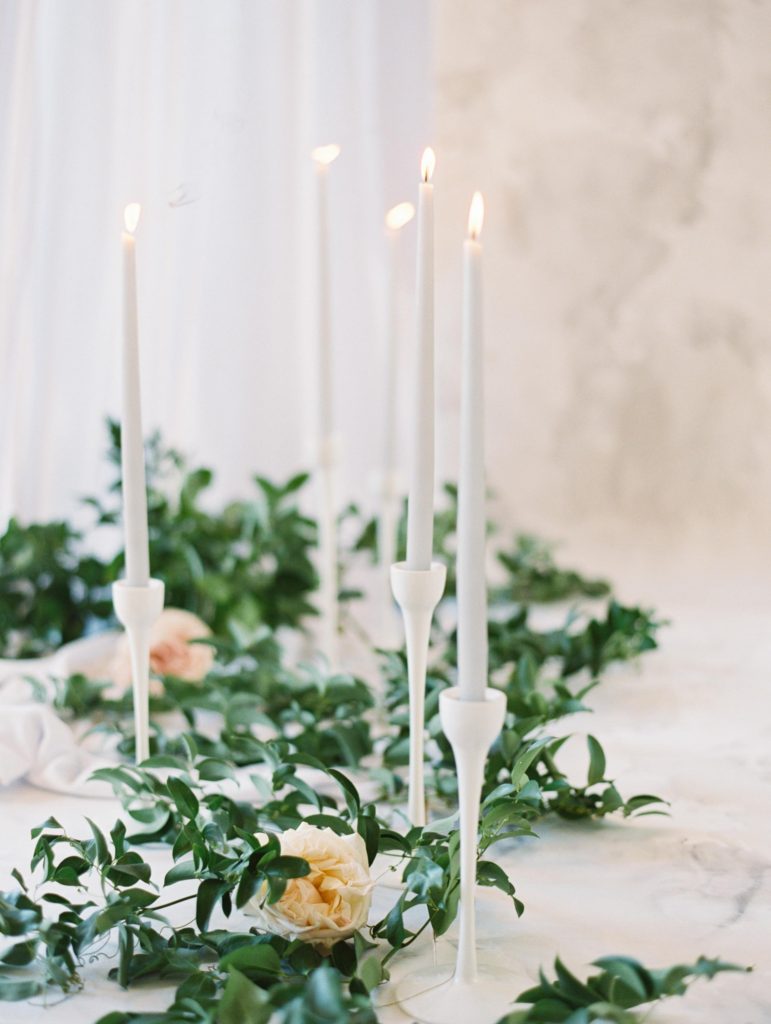 beautiful gray candles and greenery flank the aisle runner backdrop