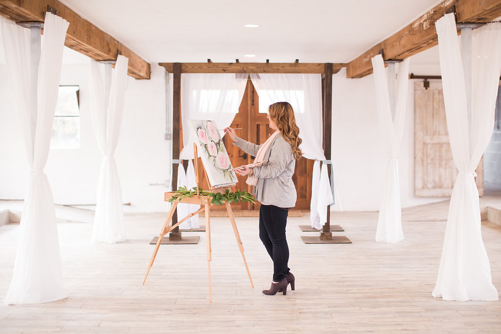 artist Brittany Branson live painting in a white barn
