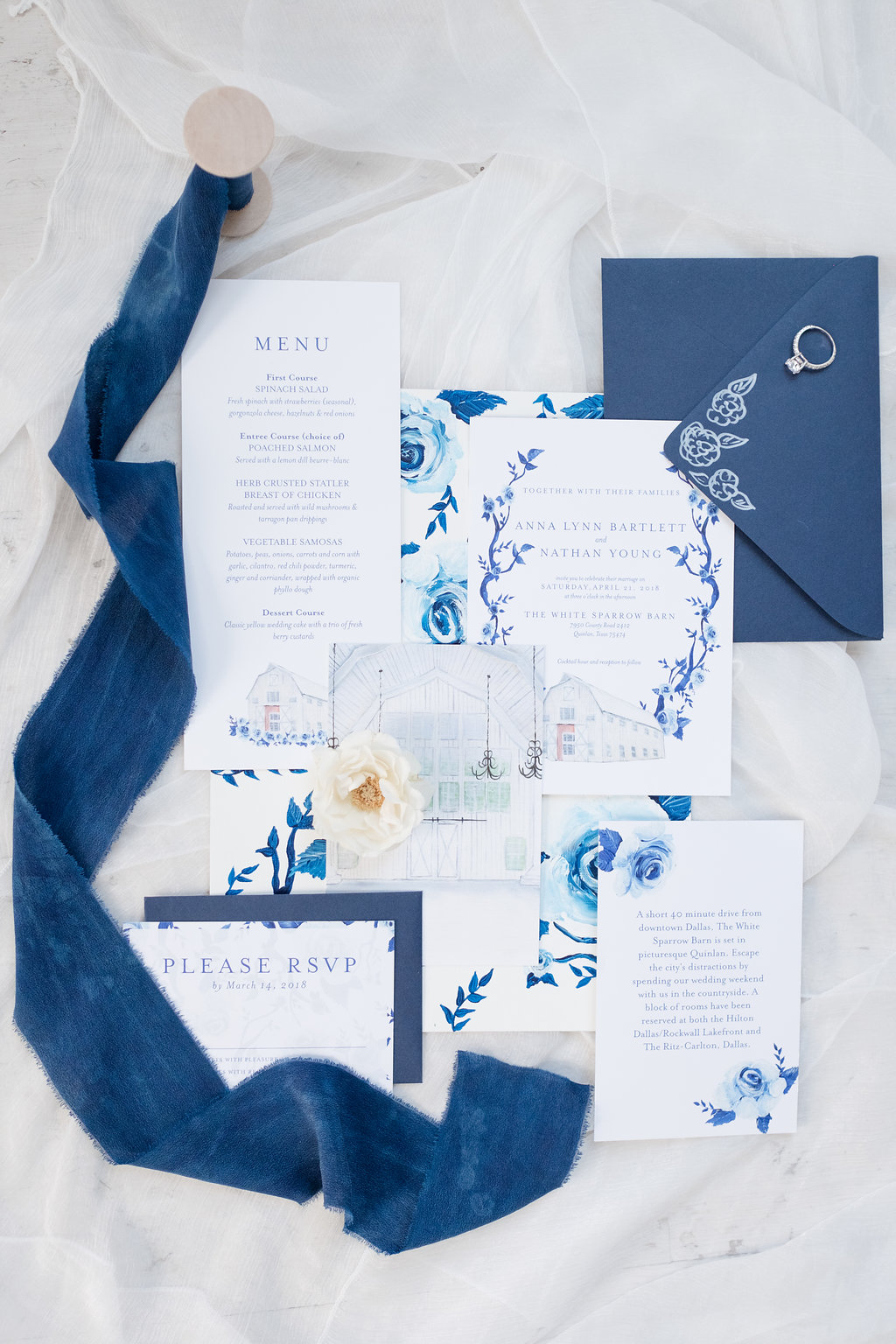 A blue and white floral wedding invitation suite professionally styled and photographed