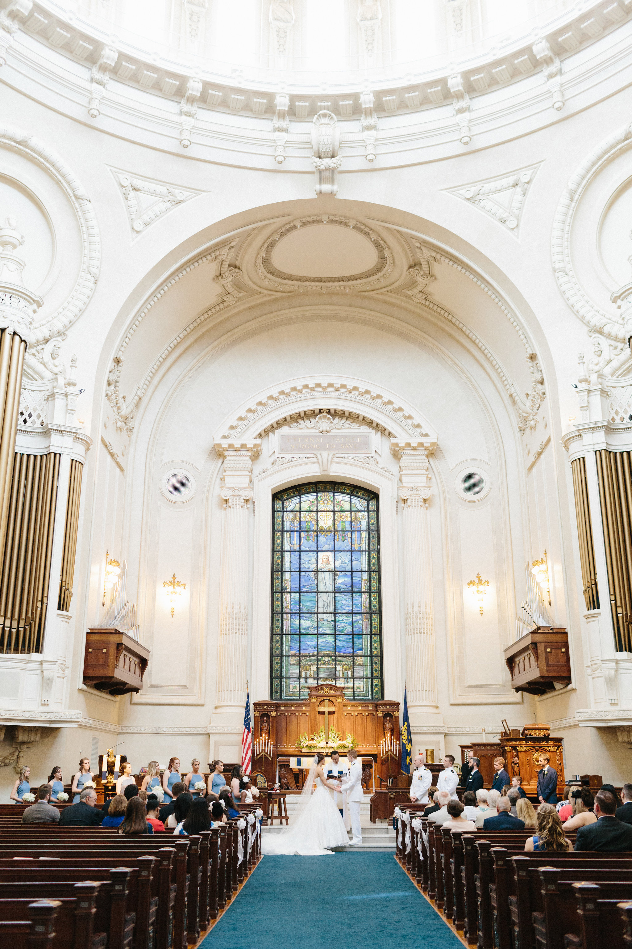 A bride and groom at the US Naval Academy Chapel altar.