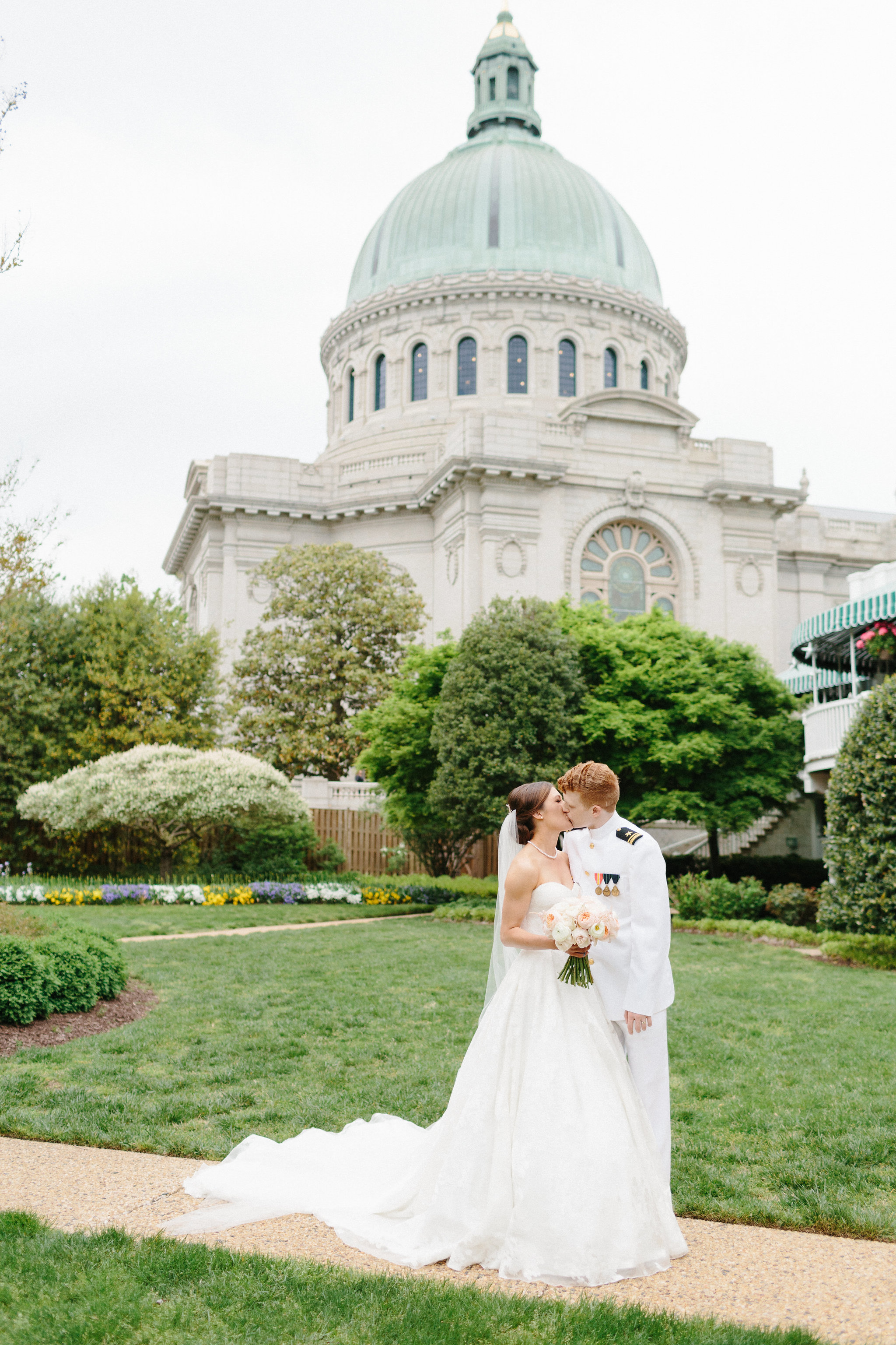 Bride and groom kissing outside of the US Naval Academy Chapel in Annapolis