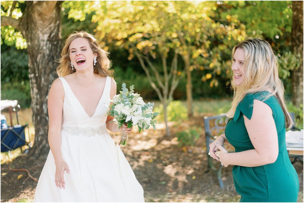 Bride reacting to her live wedding painting experience at Keswick Vineyards in Charlottesville, VA photographed by Meghan Elizabeth Photography.