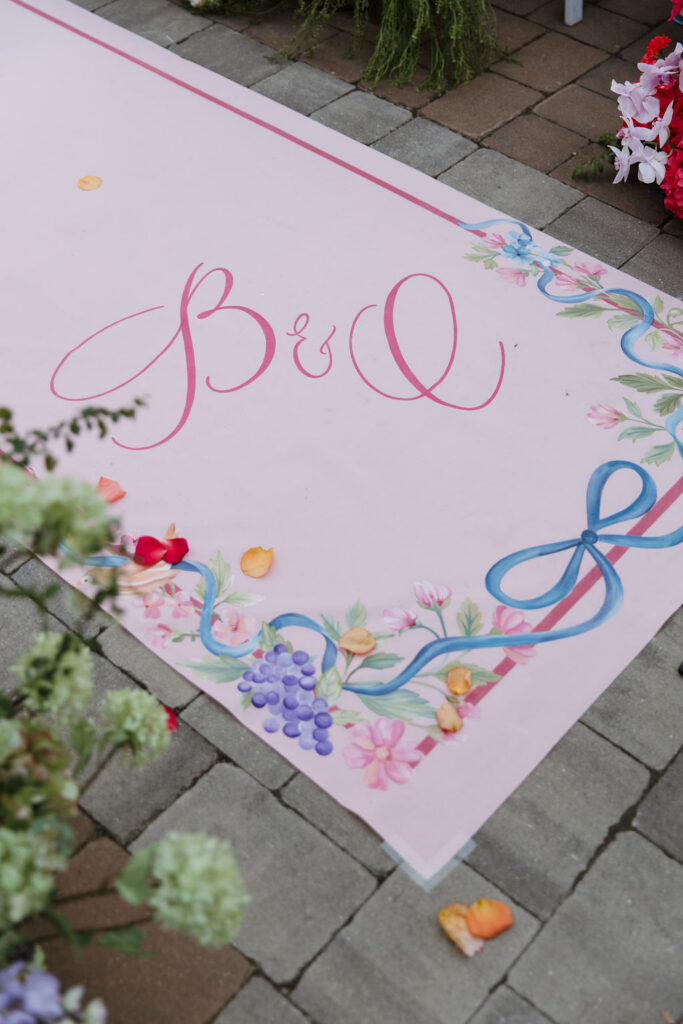 A detail shot of the custom walkway of the aisle. It features a floral illustration and calligraphy B and C letters, which is highlighted in Brittany's painting.